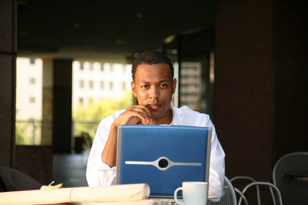 man sitting behind laptop